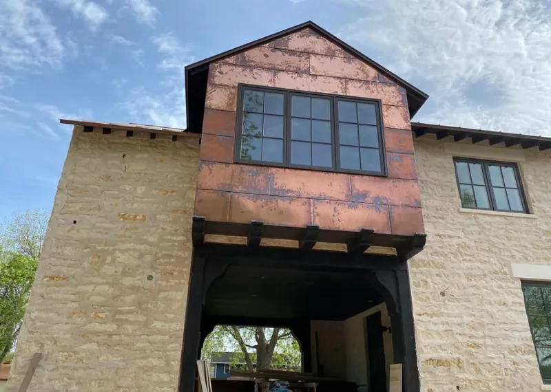 Copper metal panel facade on a stone building for Roof Repair in Burke