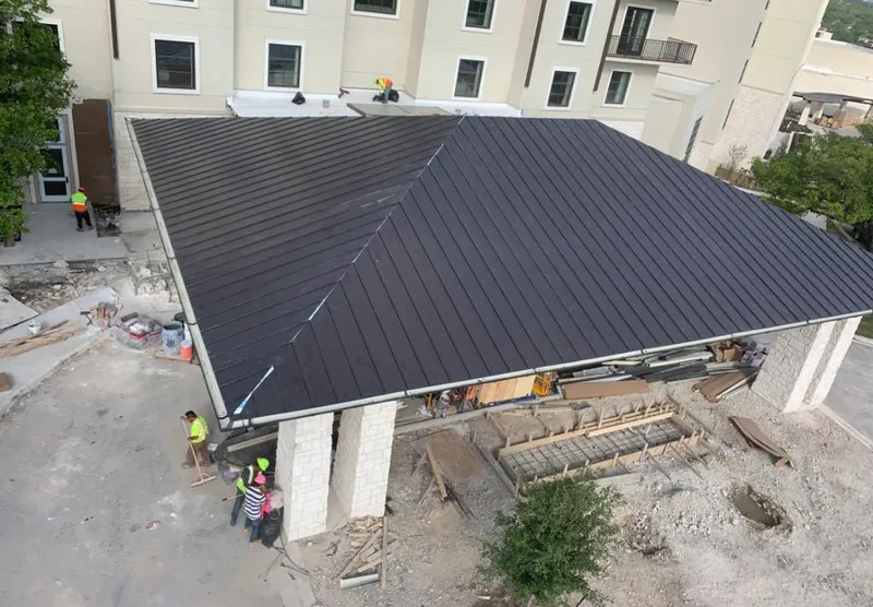 Metal roofing installation team working on a commercial building in Burke